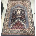 A Persian carpet of Mihrab style design, the central panel with foliate decoration on a blue,