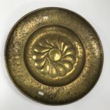 An 18th Century brass alms dish with embossed flower head decoration to centre, 51.