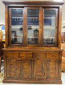An Eastern hardwood dresser with three glazed sliding doors above two drawers and two pairs of