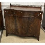 An Edwardian mahogany and cross banded serpentine fronted side cabinet with single long and two