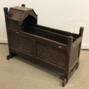 A 19th Century English oak and carved crib of typical form,