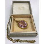 A gold mounted pink tourmaline pendant oval cut with yellow metal chain, stone approx. 2.5 cm x 1.