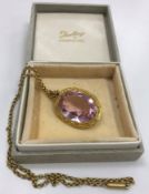 A gold mounted pink tourmaline pendant oval cut with yellow metal chain, stone approx. 2.5 cm x 1.