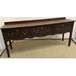 A late 18th Century oak dresser, the plank top over three drawers with brass swan neck handles,