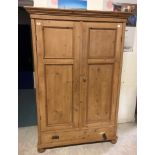 A Continental waxed pine two door wardrobe with single drawer, 125 cm wide x 54.5 cm deep x 187.