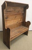 A Victorian pine tavern type settle with canopy bearing carved inscription "Wade" over a panelled