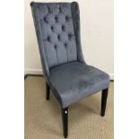 A modern faux blue grey suede buttoned shallow wing back chair on square tapered ebonised supports,