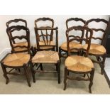 A set of six rush seat ladder back oak framed dining chairs plus another rush seat spindle back