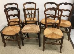 A set of six rush seat ladder back oak framed dining chairs plus another rush seat spindle back