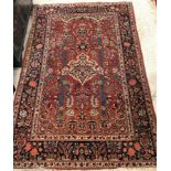 A Mihrab design style carpet, the central panel on a red ground, with foliate decoration,