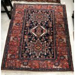 A Persian rug, the central panel set with three medallions on a dark blue ground,