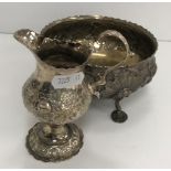 A late George III silver pedestal cream jug with later Victorian embossed floral and foliate