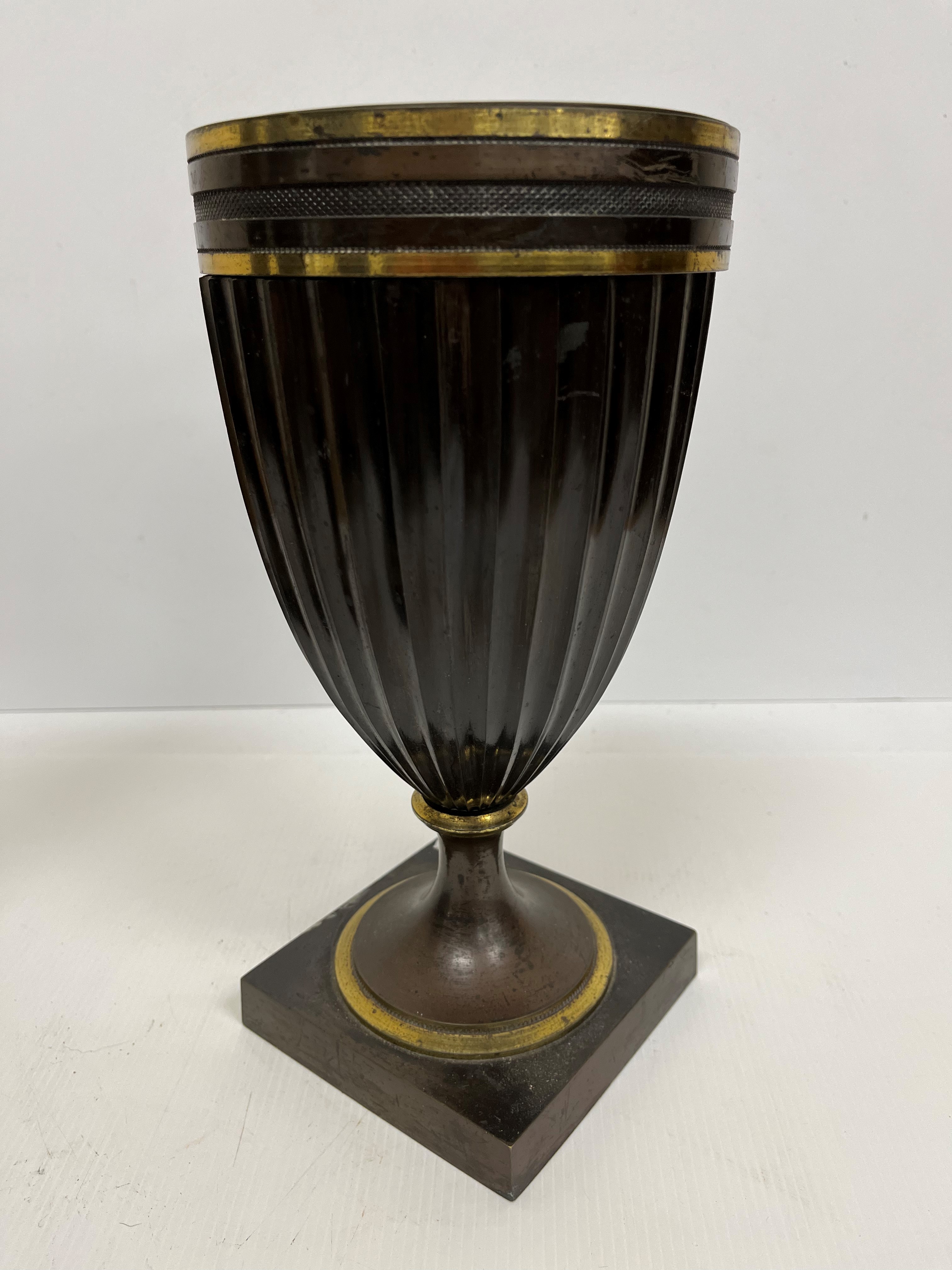 A 19th Century chocolate patinated bronze and gilt brass banded oil lamp base of fluted goblet form,