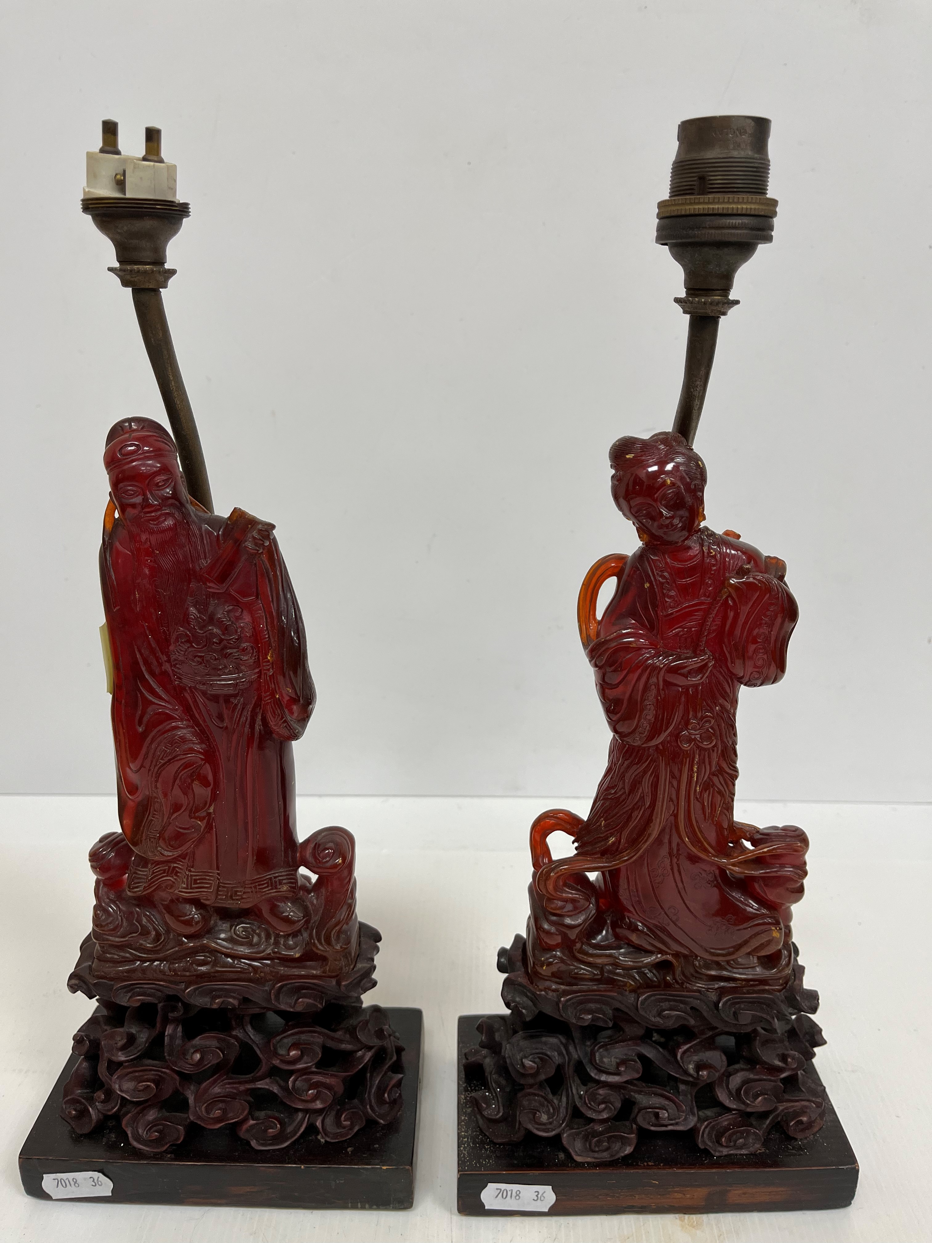 A pair of Chinese carved amber figures of a man and a woman in robes,