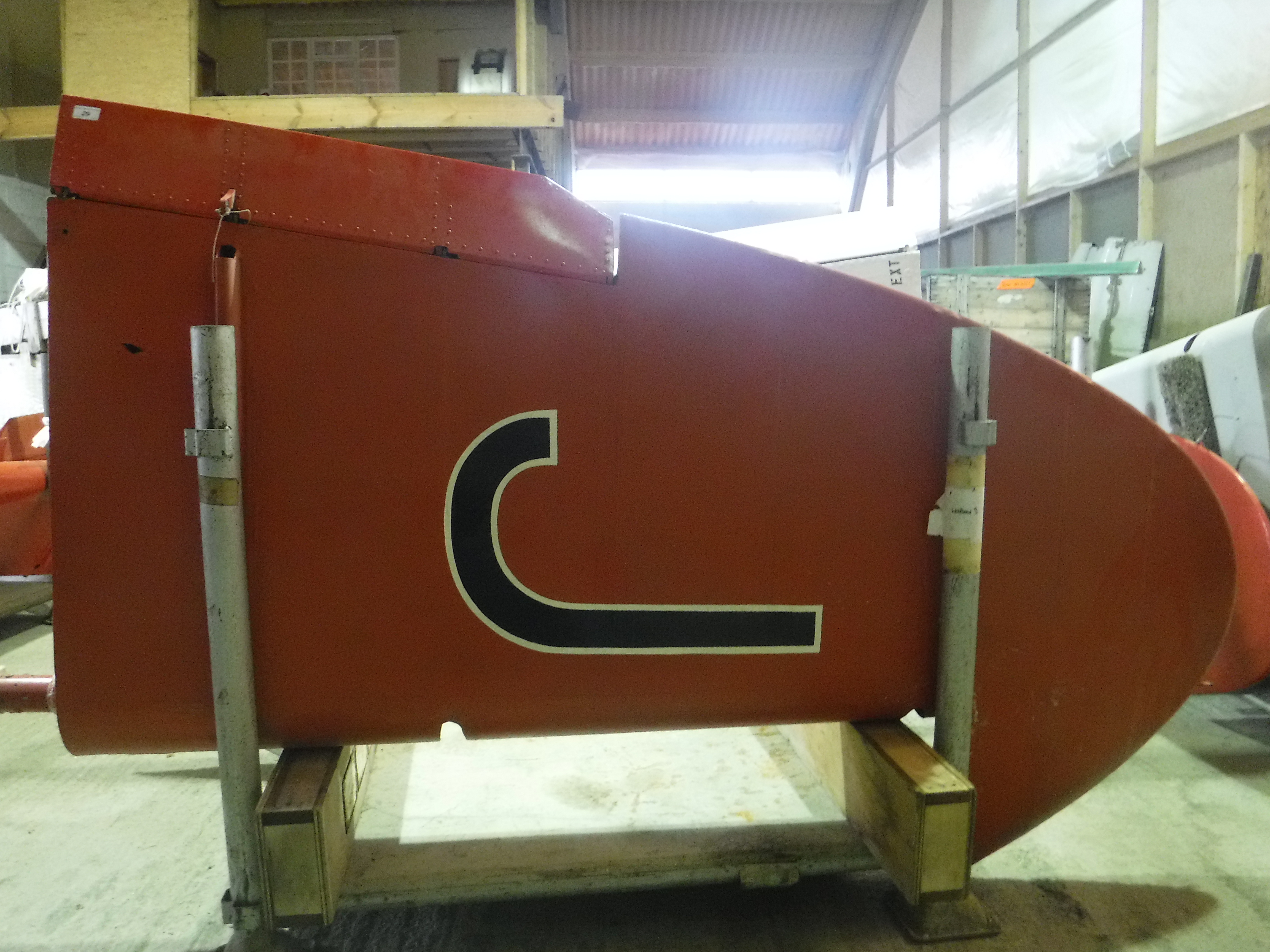 A De Havilland tail fin, red painted, approx 220 cm high, bearing Dove label inscribed "Type No.
