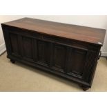 A 17th Century and later oak coffer, the replacement top over a five panel front,