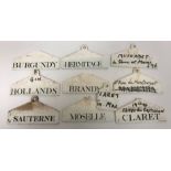 A collection of Wedgwood porcelain wine tags including "Hollands", "Hermitage", "Sauternes",