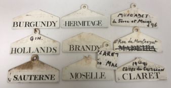 A collection of Wedgwood porcelain wine tags including "Hollands", "Hermitage", "Sauternes",