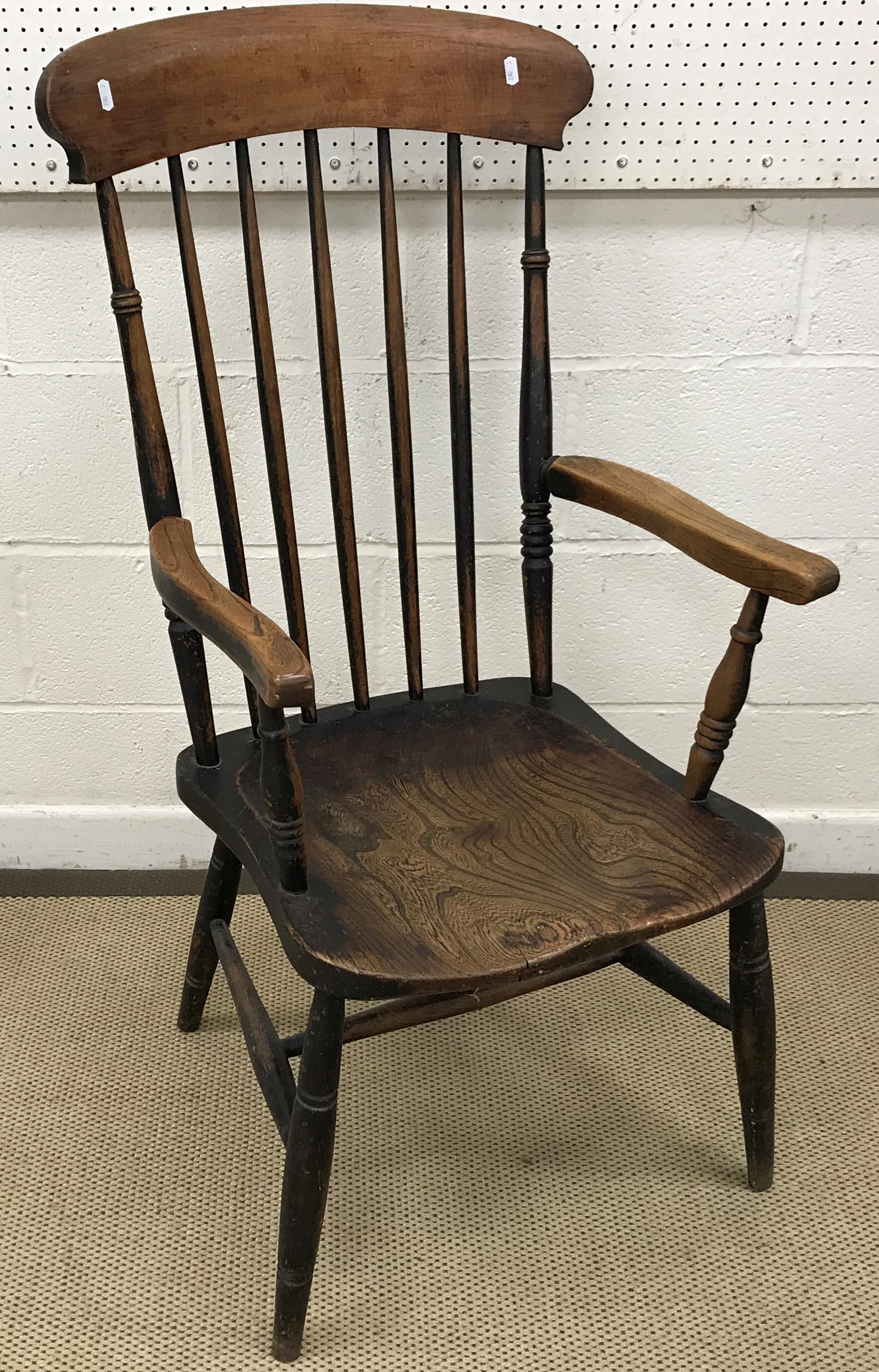 A Victorian beech and elm stick back elbow chair on turned legs united by an H stretcher together