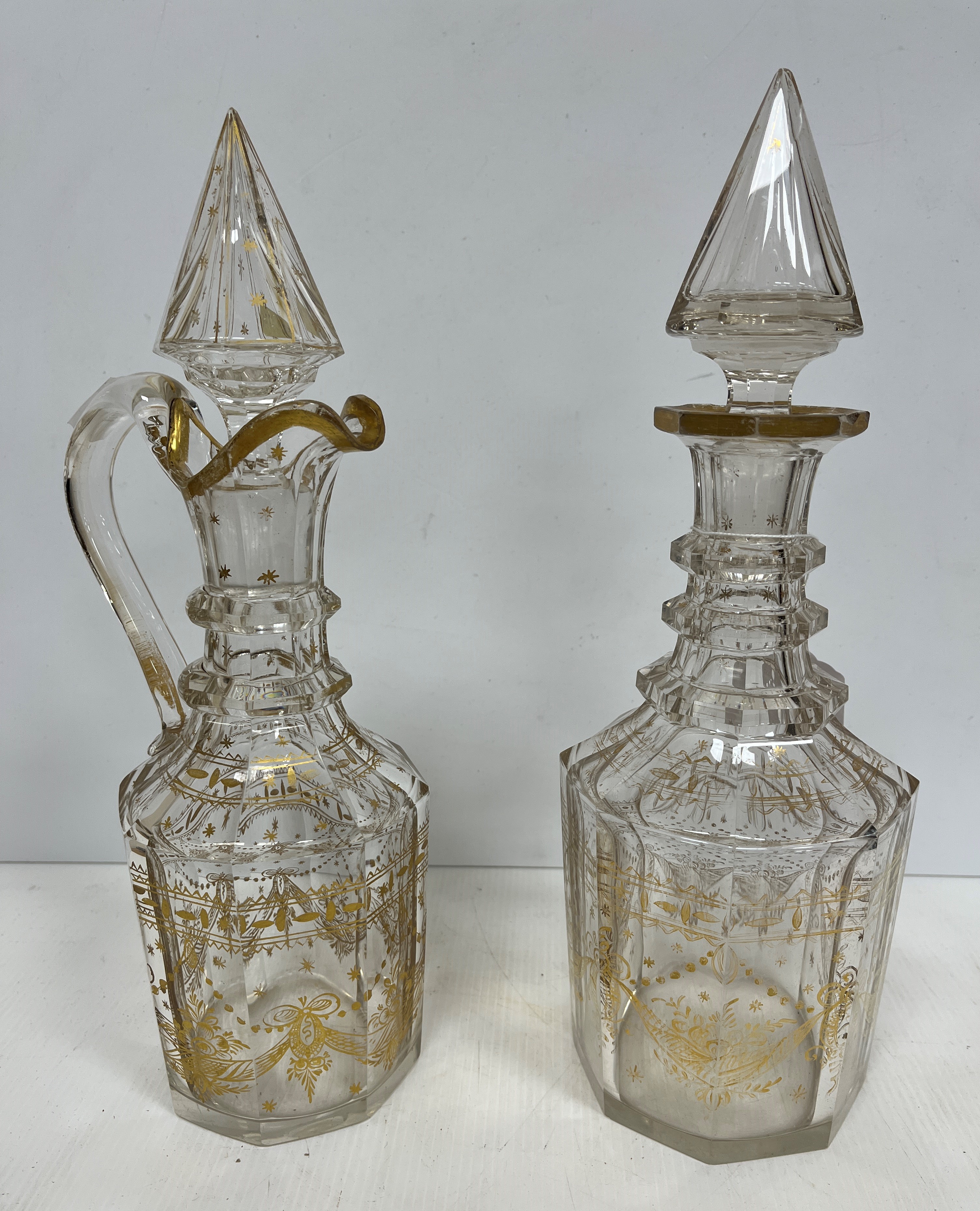 A pair of 19th Century facet cut mallet shaped decanters and stoppers with gilded decoration,