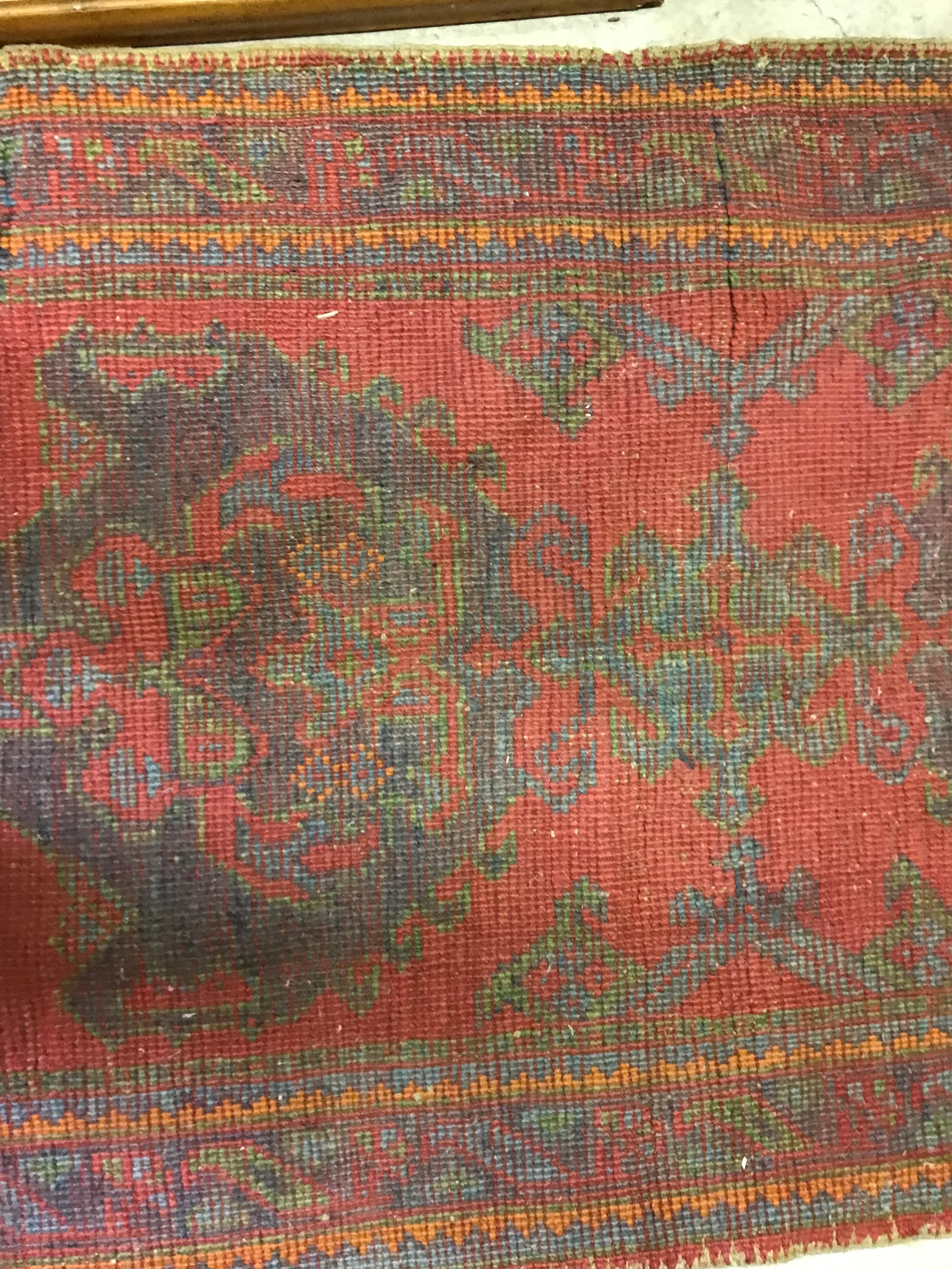 A Donegal rug, the central panel set with stylised cross medallion on a red ground, - Image 2 of 26