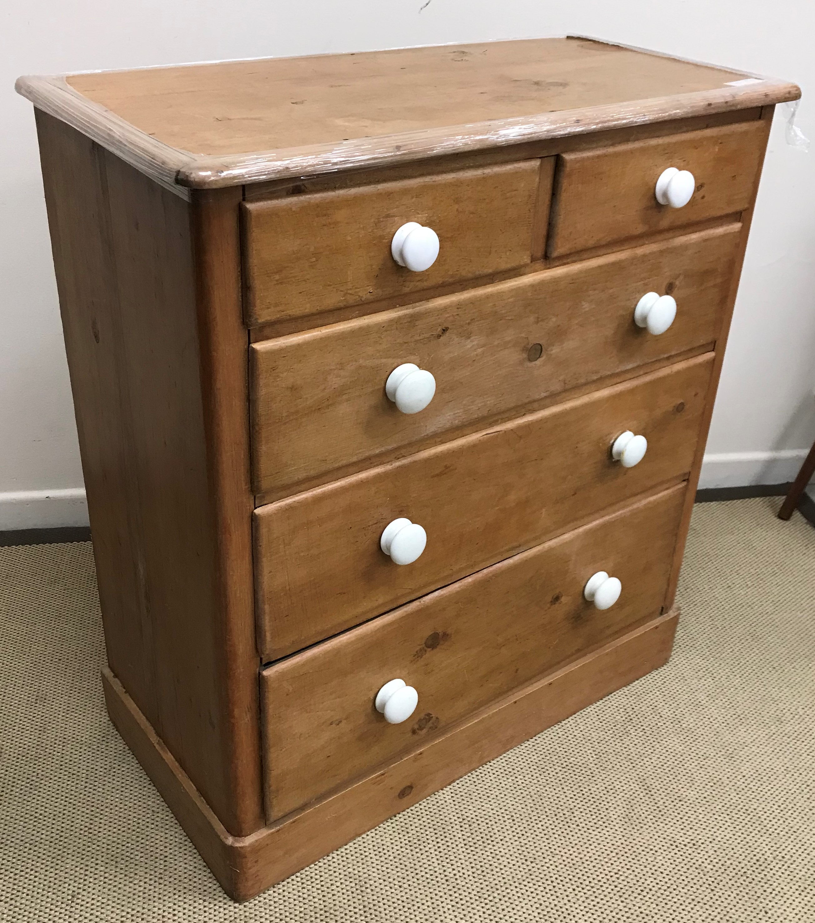 A Victorian pine chest of two short over three long graduated drawers with white glazed pottery