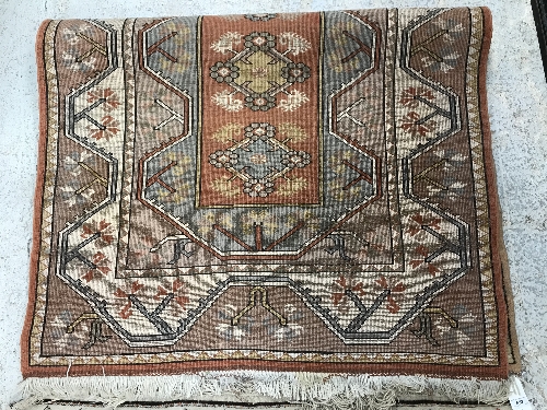 A Caucasian rug, the central panel set with five repeating medallions on a salmon pink ground, - Image 12 of 13