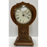 A circa 1900 walnut cased balloon style mantle clock with carved decoration to the column,