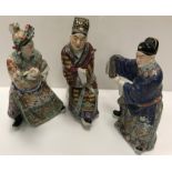 A set of three 19th Century Chinese polychrome decorated figures, one seated, one bearing sword,