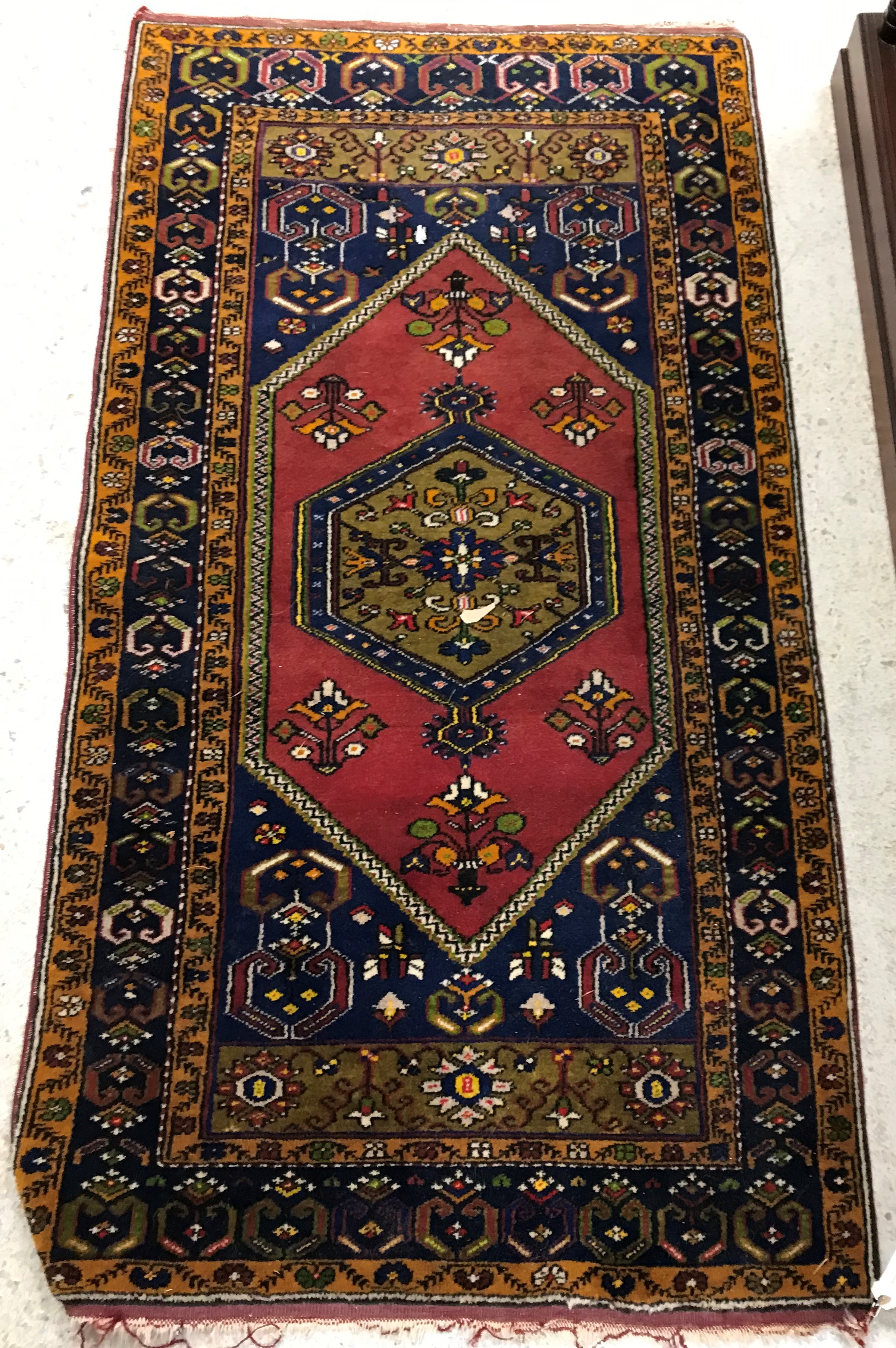 A Caucasian rug, the central panel set with lozenge shaped medallion on a red and blue ground,