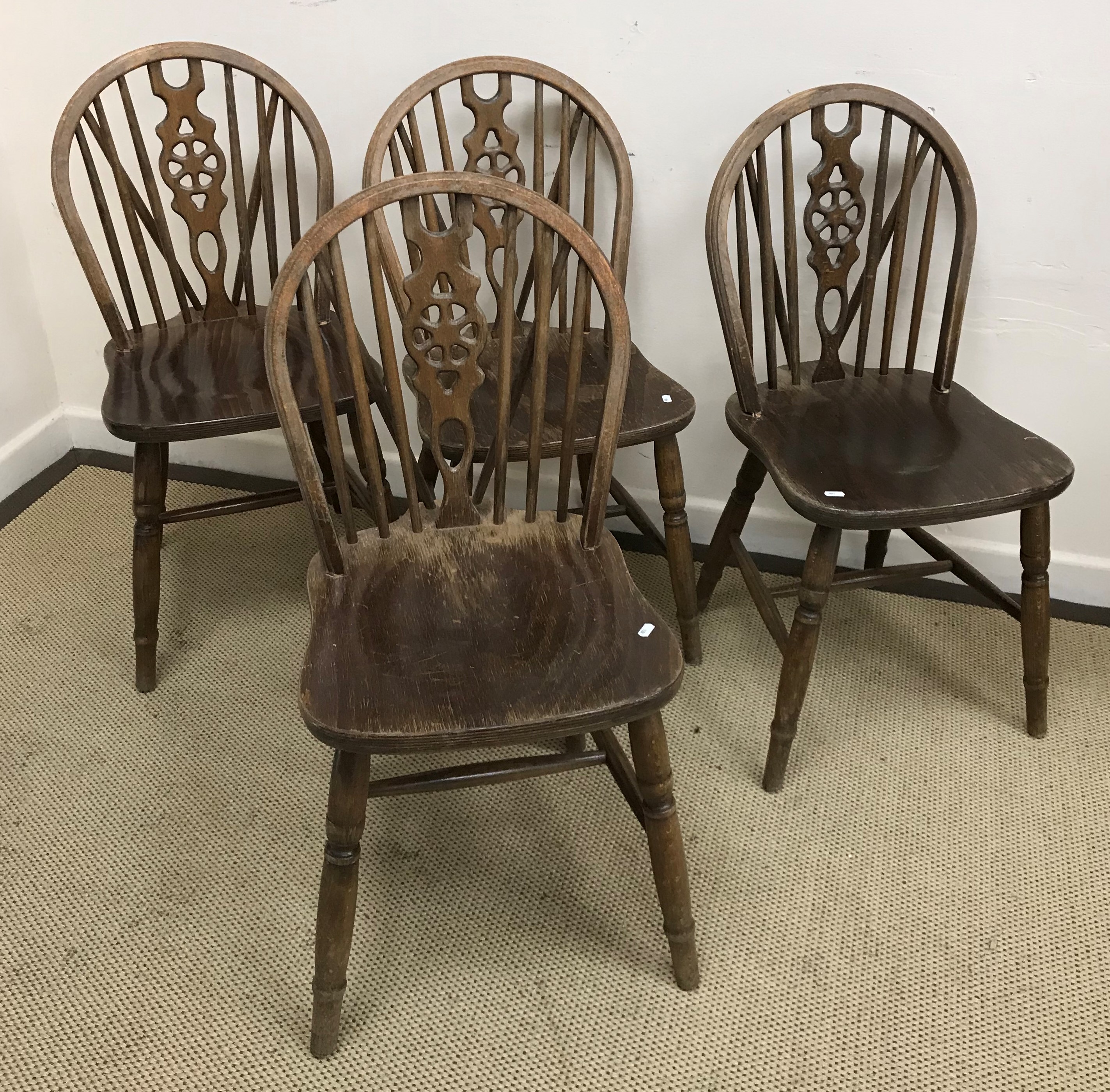 A set of four modern beech wheel and stick back kitchen chairs,