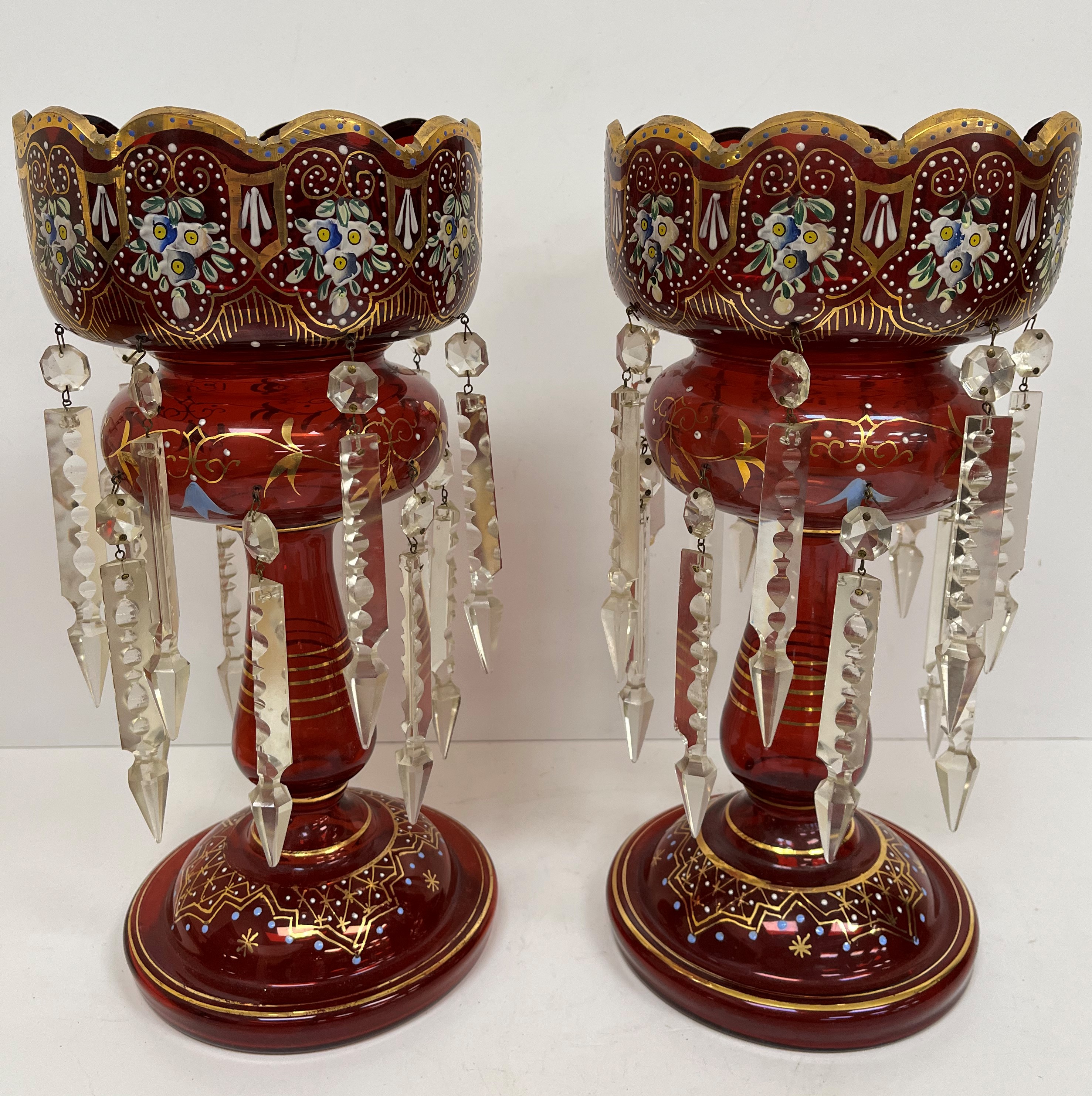 A pair of ruby glass table lustres with painted floral and gilded decoration,