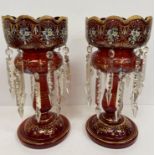 A pair of ruby glass table lustres with painted floral and gilded decoration,