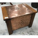 An Arts and Crafts style oak coal box with copper panels set with embossed floral decoration and