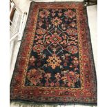 A Persian carpet, the central panel set with all-over floral sprays on a blue ground,