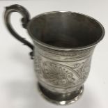 A Victorian silver christening mug of inverted bell form with engraved scrolling handle raised on a