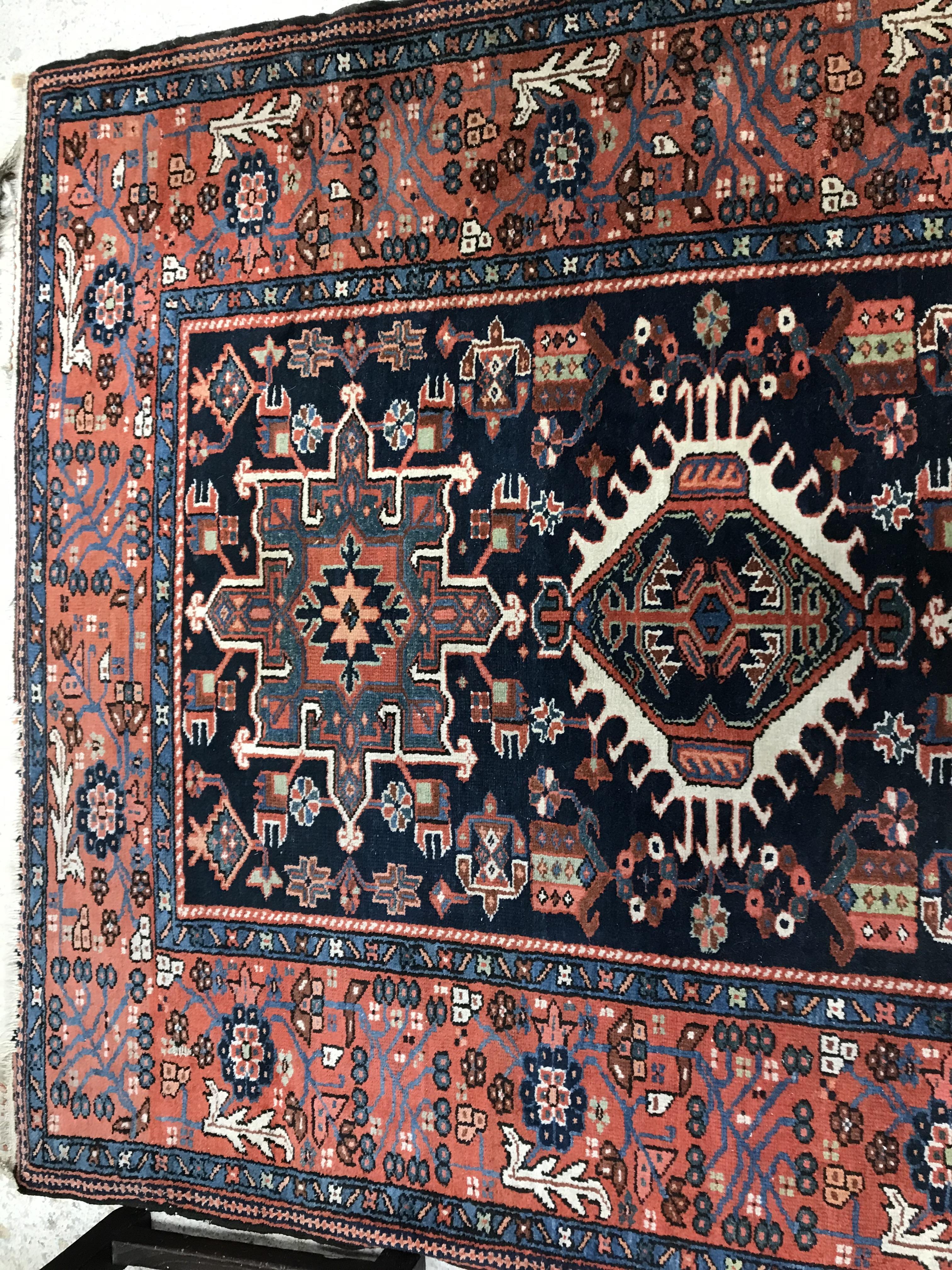 A Persian rug, the central panel set with three medallions on a dark blue ground, - Image 3 of 7
