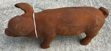 A cast metal figure of a pig, with rust