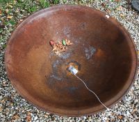 A cast iron fire pit with rust patinatio