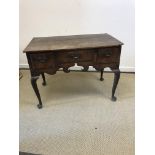 An 18th Century oak lowboy, the two plank top over three drawers and fretwork carved frieze,