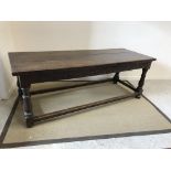 An 18th Century oak refectory style dining table, the three plank top above a lunette carved frieze,