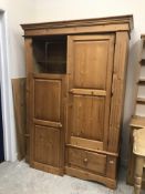 A modern pine wardrobe with two cupboard doors over two drawers on bracket feet 138 cm wide x 56.