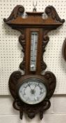 A circa 1900 carved oak cased aneroid barometer thermometer 85 cm high x 34 cm wide