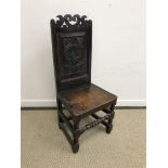 A 17th Century style oak panel seated hall chair with crown carved top rail over a Tudor rose and