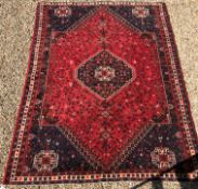 A Shriaz carpet, the central panel set with blue ground medallion on a red and blue ground,