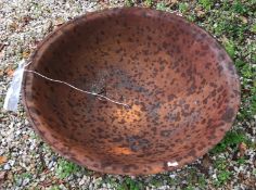A cast iron fire pit with rust patination,