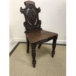 A pair of Victorian oak panel seated hall chairs with pierced medallion backs on baluster turned