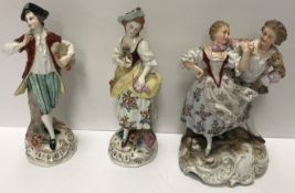 A Volkstedt figure of a couple in 18th Century dress dancing on a scrollwork decorated base,