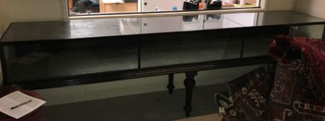 A late Victorian ebonised museum type display cabinet of three sections enclosing a single display