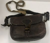 A cowhide cartridge bag (75) embossed "E